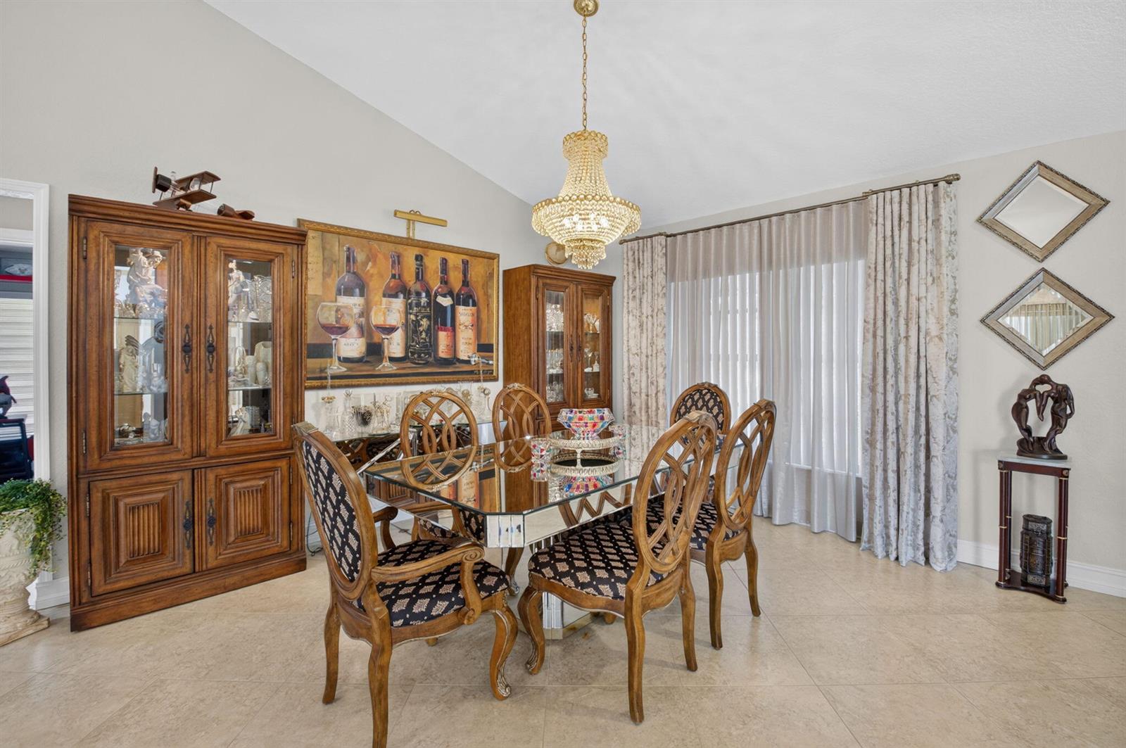 A formal dining room features a glass-topped table, wooden chairs, a crystal chandelier, and cabinets — 19600 Sedgefield Terrace, Boca Raton FL 33498, BOCA RATON, FL