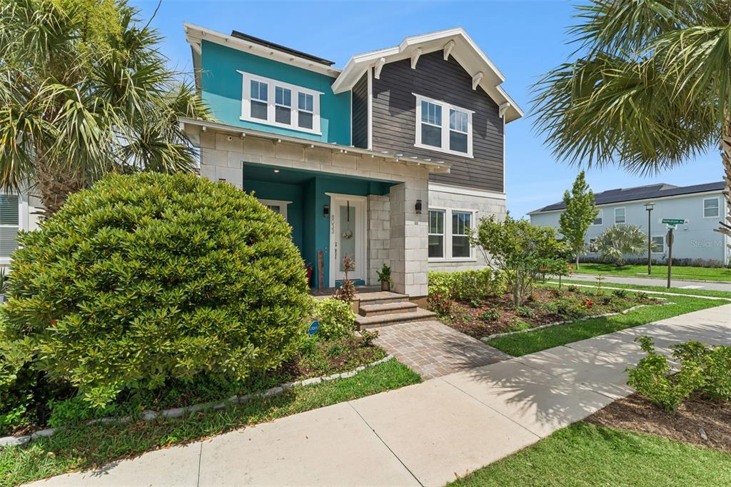 A two-story house features teal and dark gray siding with a stone-accented front entryway — 8033 NEMOURS PARKWAY, ORLANDO, FL