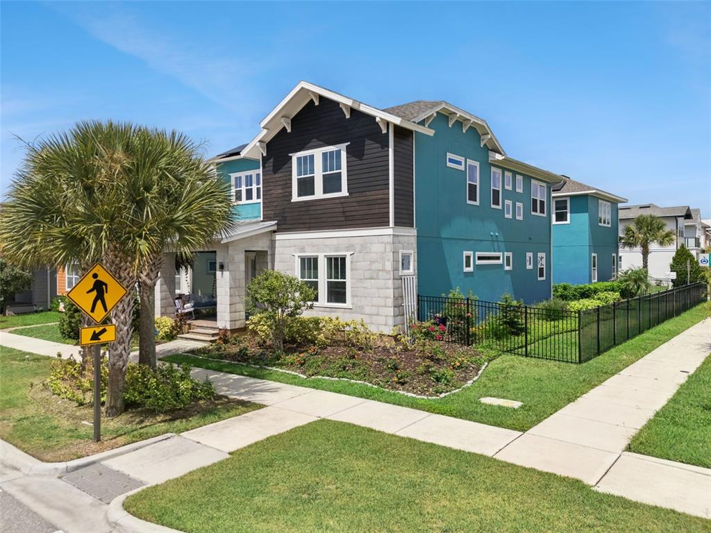 A two-story house with teal and dark wood siding features a stone-veneer lower level — 8033 NEMOURS PARKWAY, ORLANDO, FL