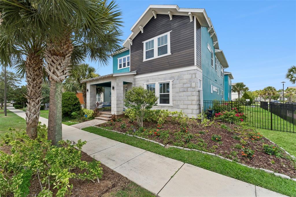 A two-story house with a teal and dark wood exterior features a stone-block front porch — 8033 NEMOURS PARKWAY, ORLANDO, FL