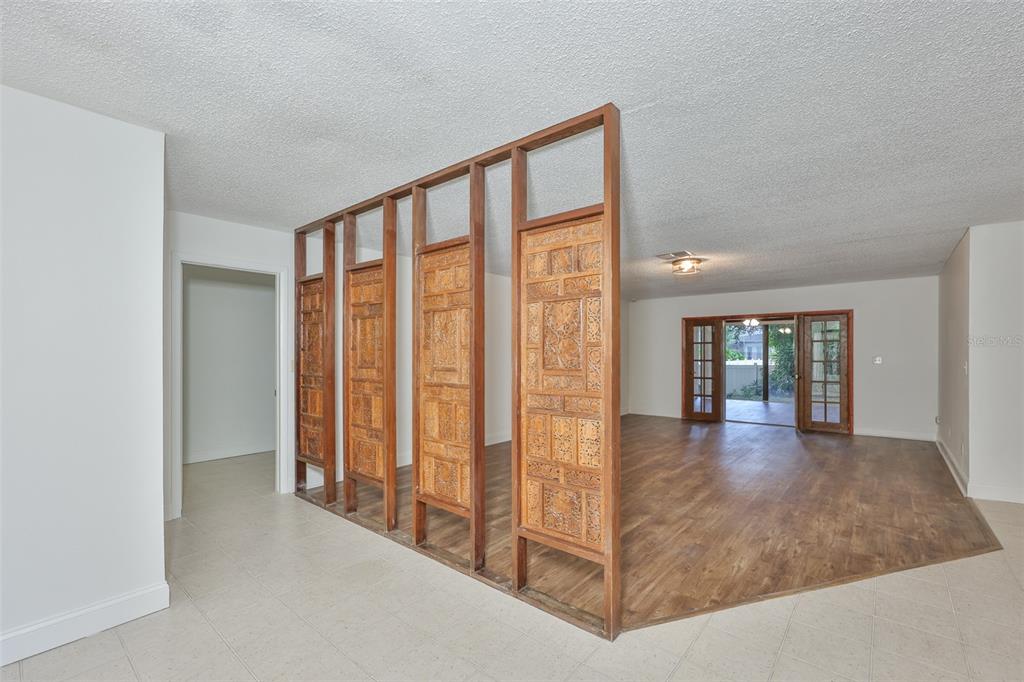 A room with a decorative wooden room divider separating tiled and wood-look flooring — 2823 HERON PLACE, CLEARWATER, FL