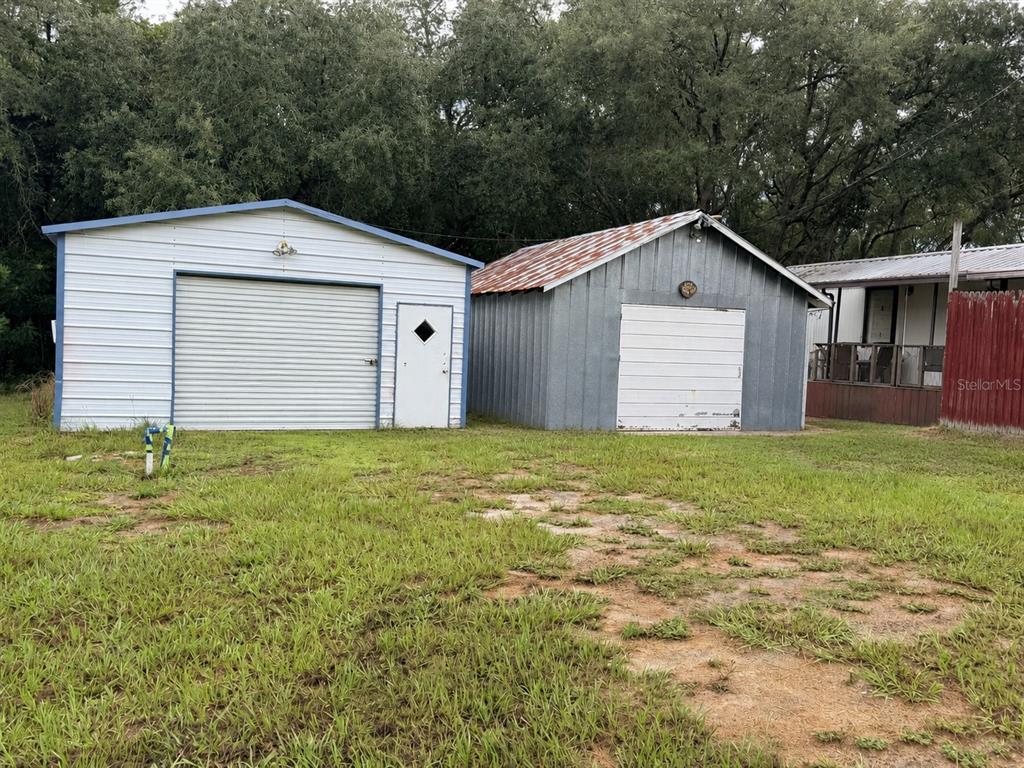 Two detached metal garages stand on a grassy lot next to a mobile home — 355 NE 436 AVENUE, OLD TOWN, FL