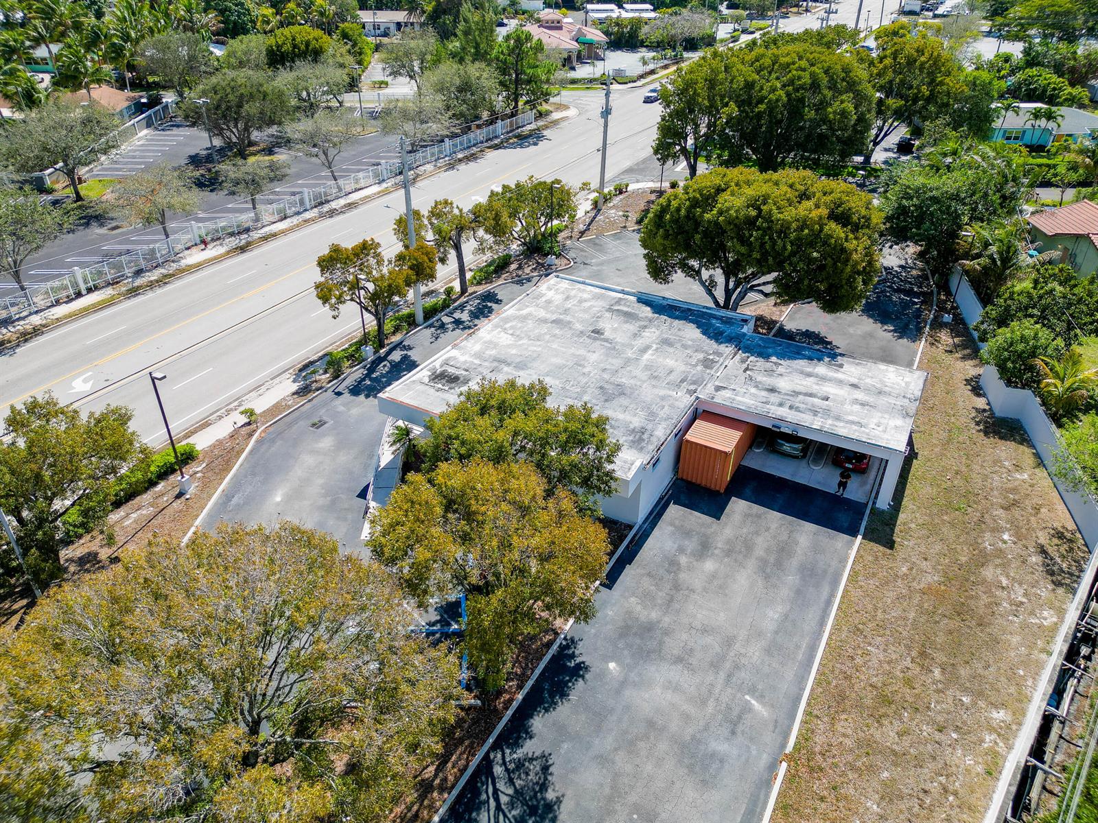 An aerial view shows a commercial building with a flat roof, parking lot, and trees — 2419 S Seacrest Boulevard, Boynton Beach FL 33435, BOYNTON BEACH, FL