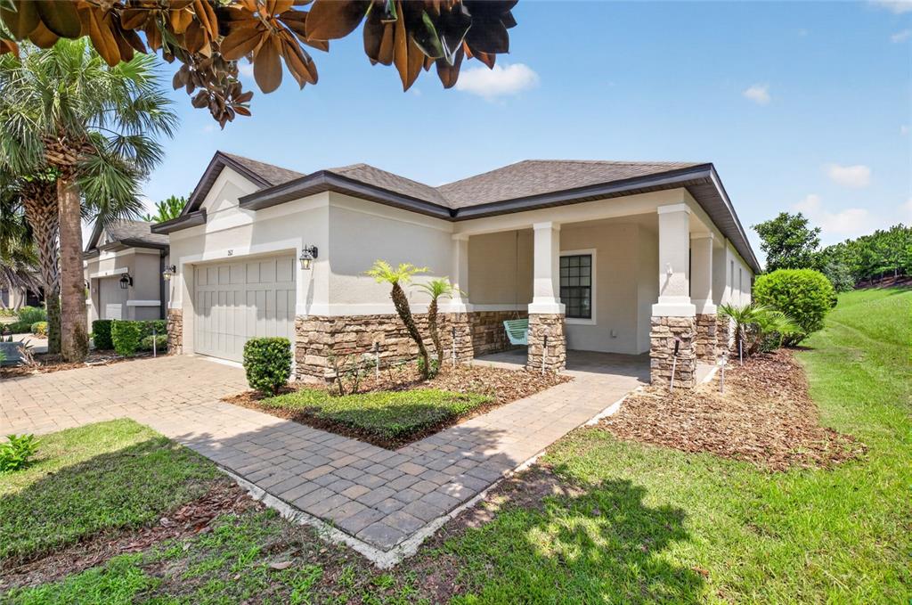 A single-story house with a stone-accented facade, a two-car garage, and a covered front porch — 2612 FRAZEEK COURT, CLERMONT, FL
