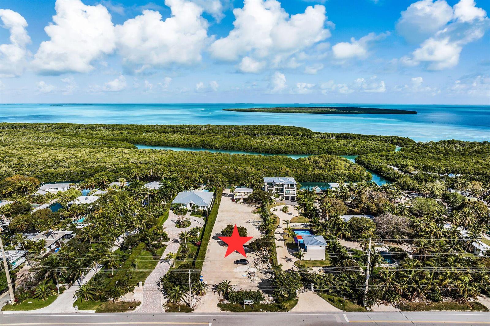 An aerial view shows a vacant lot marked with a red star near the ocean — 77340 Overseas Highway, Islamorada FL 33036, ISLAMORADA, FL