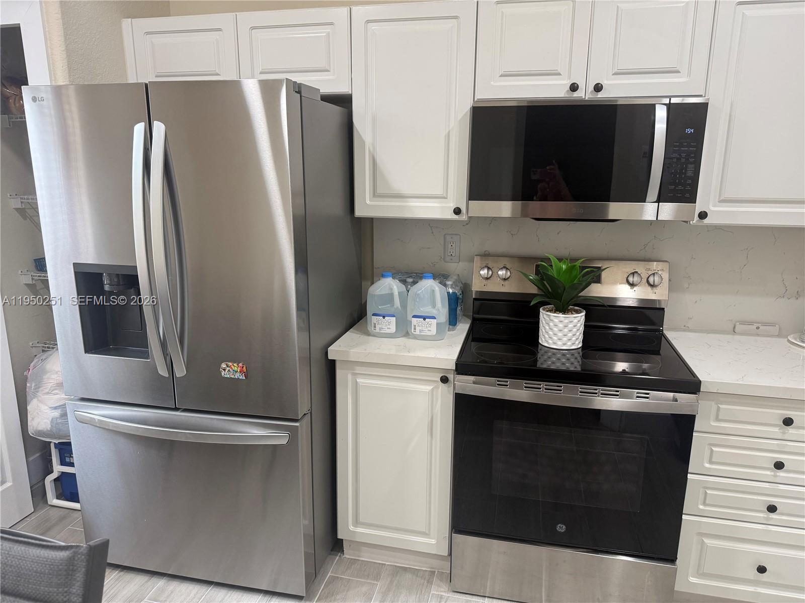 A kitchen features white cabinets, stainless steel appliances, and a quartz countertop — 5400 NW 107th Ave # 416, Doral FL 33178, DORAL, FL