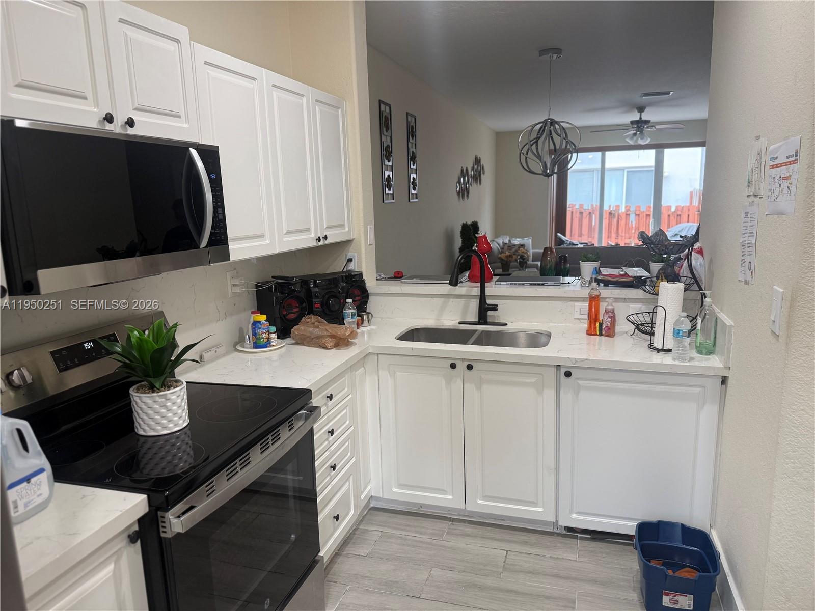 A kitchen features white cabinets, stainless steel appliances, a double sink, and quartz countertops — 5400 NW 107th Ave # 416, Doral FL 33178, DORAL, FL