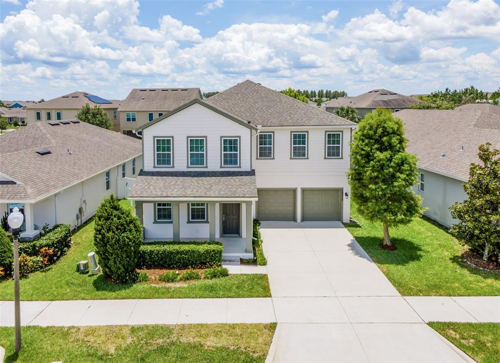 A two-story suburban house with white siding, a gray shingled roof, and a two-car garage — 15372 SUGAR CITRUS DRIVE, WINTER GARDEN, FL