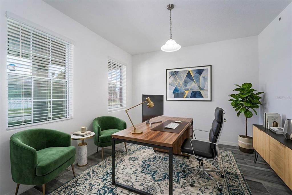 A home office features a wooden desk, two green velvet chairs, and a patterned area rug — 15372 SUGAR CITRUS DRIVE, WINTER GARDEN, FL