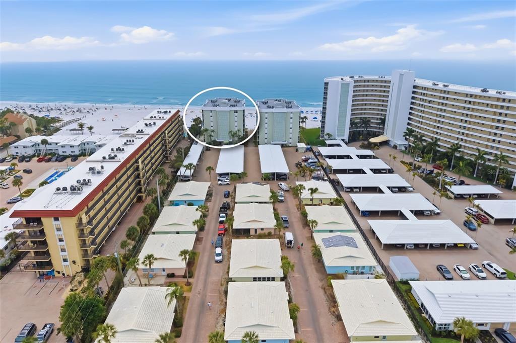 An aerial view shows a beachside apartment complex with a circled building near the ocean — 6312 MIDNIGHT PASS ROAD UNIT 305S, SARASOTA, FL