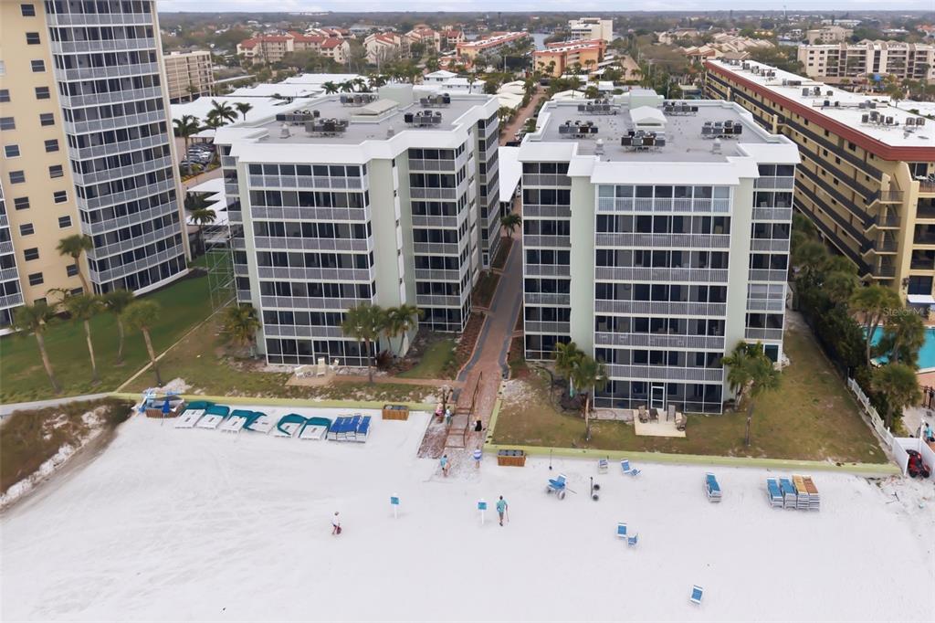 An aerial view shows two multi-story apartment buildings situated directly on a sandy beach — 6312 MIDNIGHT PASS ROAD UNIT 305S, SARASOTA, FL