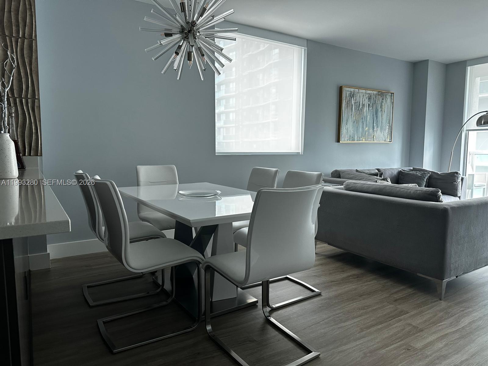 A dining area features a white table, six chairs, and a modern sputnik chandelier — 500 Brickell Ave # 3307, Miami FL 33131, MIAMI, FL