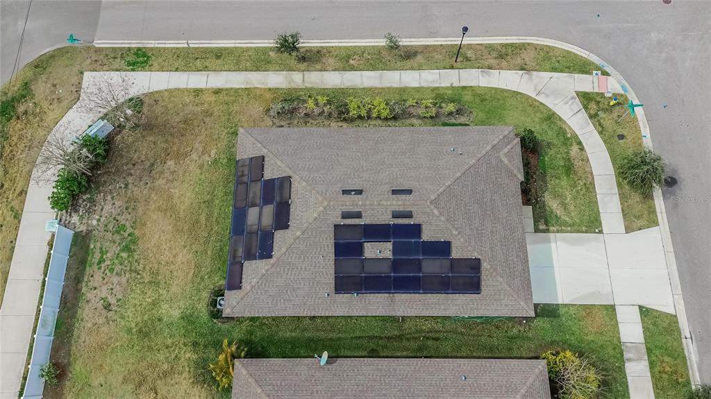 An aerial view shows a residential roof with two sections of installed solar panels — 901 GOLDEN SHINER AVENUE, RUSKIN, FL