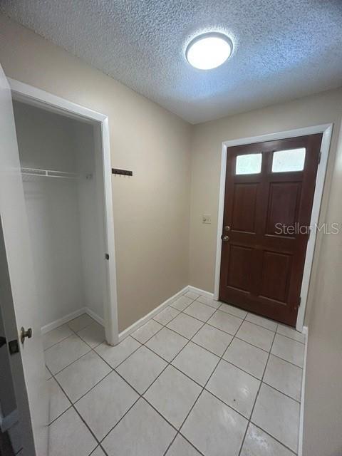 An entryway features a tiled floor, a brown front door, and an open storage closet — 563 HOLBROOK CIRCLE, LAKE MARY, FL