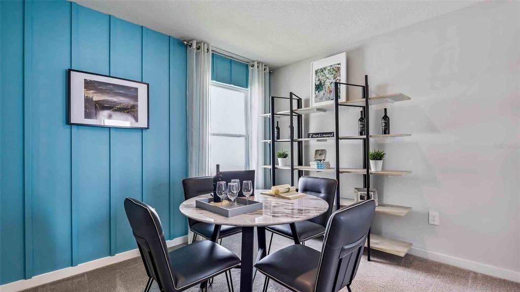 A dining room features a blue accent wall, a round marble table, and open shelving — 18232 BEEHIVE TERRACE, LAKEWOOD RANCH, FL