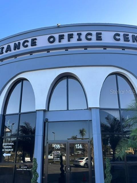 The exterior of a blue office building features arched windows and a central glass entrance — 8421 S ORANGE BLOSSOM TRAIL UNIT 441, ORLANDO, FL