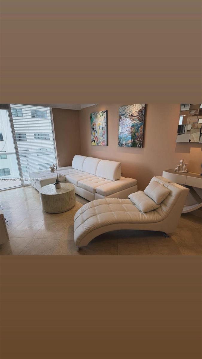 A living room features a white sectional sofa, a chaise lounge, and a circular coffee table — 6365 Collins Ave # 906, Miami Beach FL 33141, MIAMI BEACH, FL