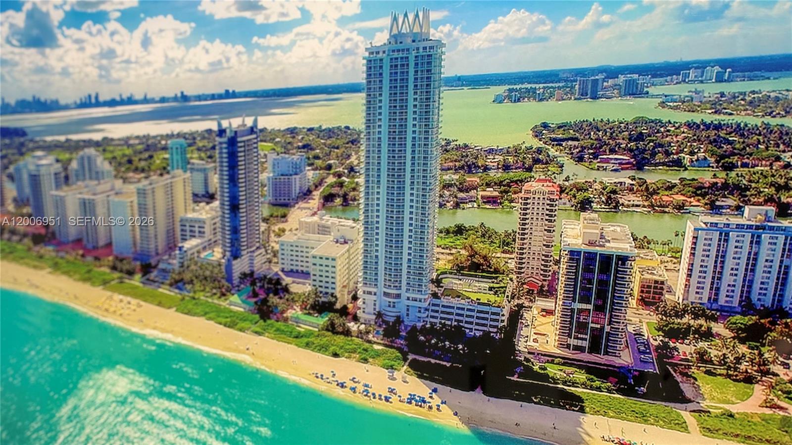 An aerial view of a tall residential skyscraper situated on a sandy beach — 6365 Collins Ave # 906, Miami Beach FL 33141, MIAMI BEACH, FL