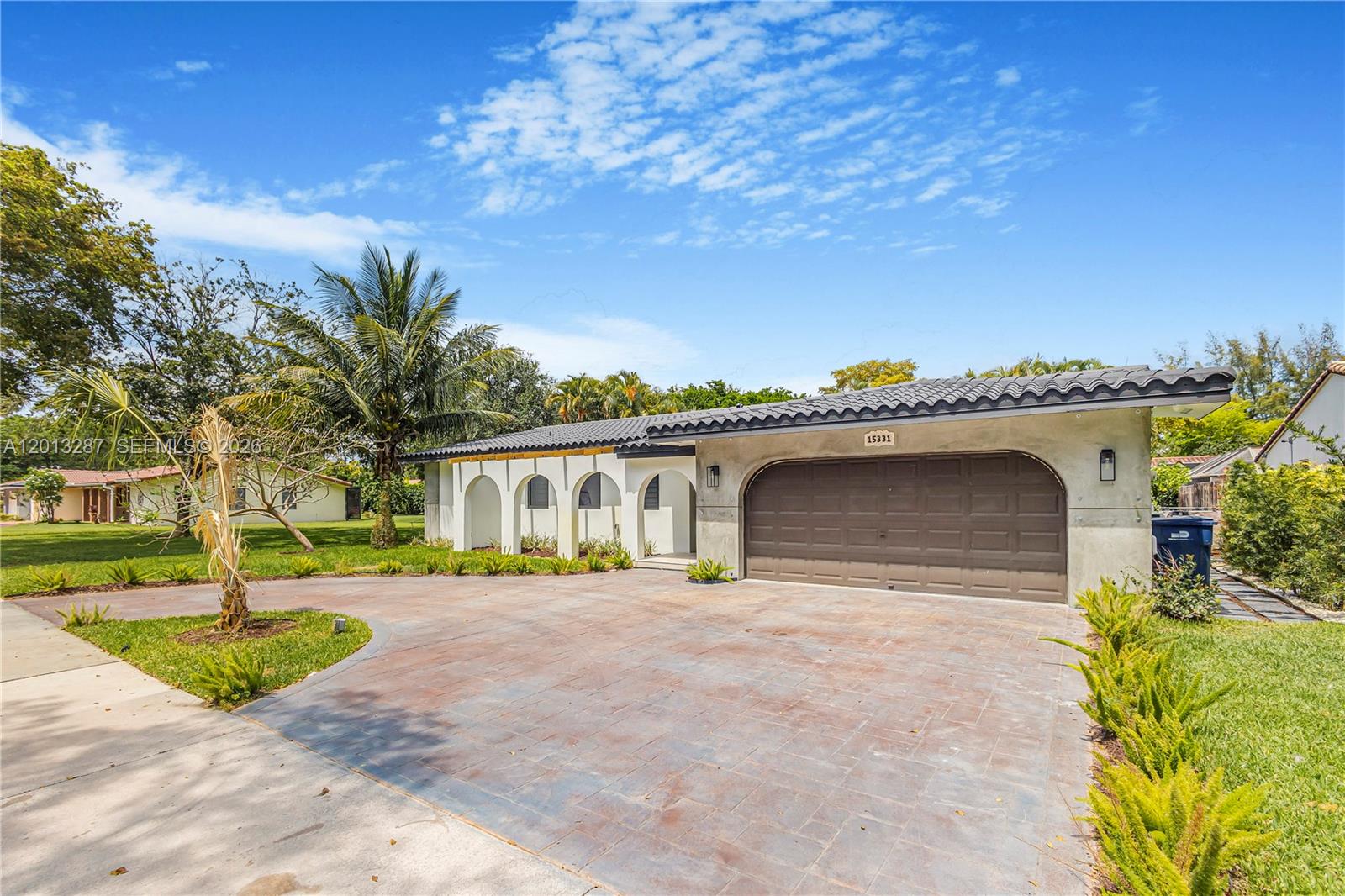 A single-story house features a brown garage door, arched entryway, and a paved driveway — 15331 Turnbull Dr, Miami Lakes FL 33014, MIAMI LAKES, FL