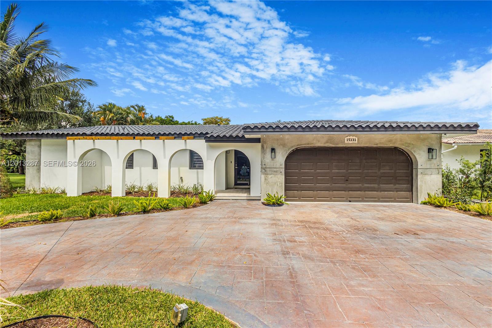 A single-story house with a white stucco facade, arched entryways, and a brown garage door — 15331 Turnbull Dr, Miami Lakes FL 33014, MIAMI LAKES, FL