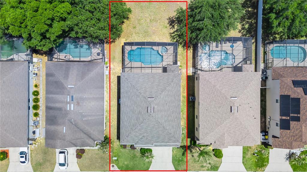 An aerial view shows a house with a screened-in pool and a fenced backyard — 200 ANDOVER DRIVE, DAVENPORT, FL