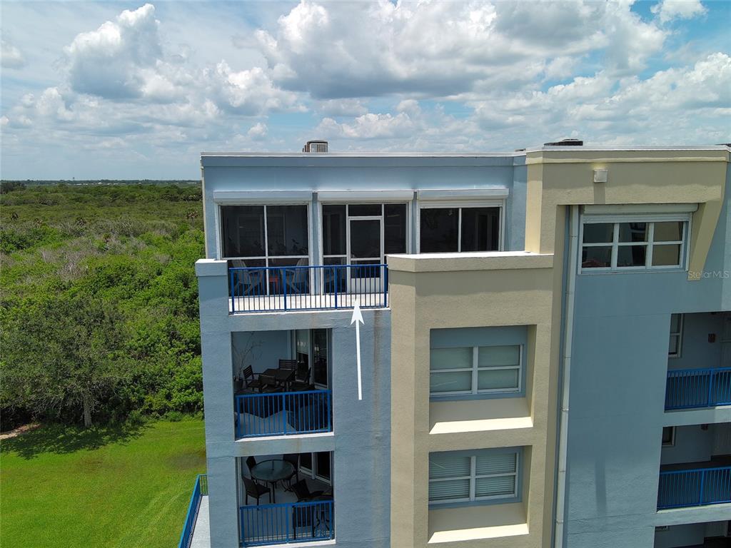 An exterior view of a multi-story apartment building featuring stacked balconies with blue railings — 5300 S ATLANTIC AVENUE UNIT 5601, NEW SMYRNA BEACH, FL