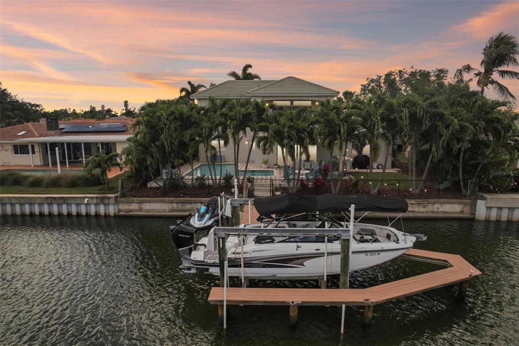 An aerial view of a waterfront house with a pool, palm trees, and a boat lift — 2032 MASSACHUSETTS AVENUE NE, ST PETERSBURG, FL