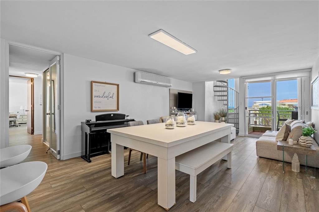 A bright dining and living area features a large white table, piano, and balcony access — Castillos Del Mar LAURO PIÑERO UNIT KC-PH, CEIBA, PR