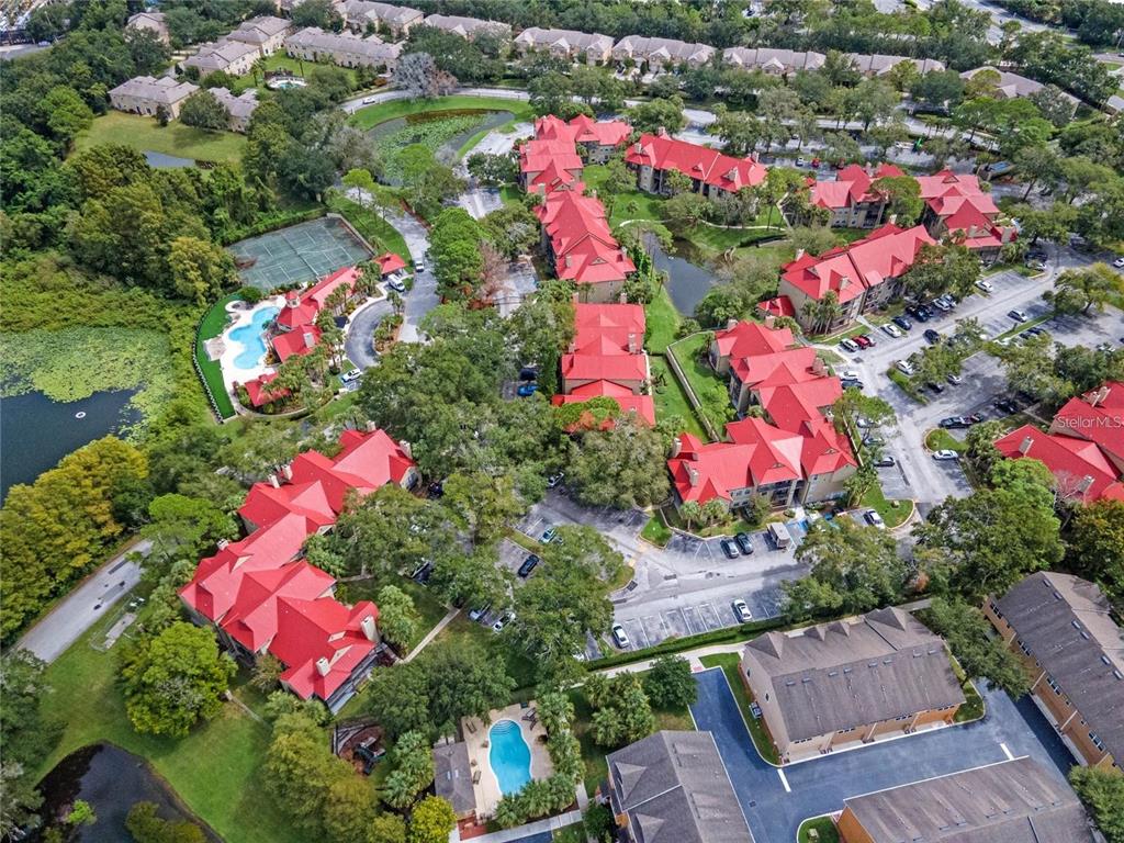 An aerial view shows a residential apartment complex with red roofs, swimming pools, and parking — 236 AFTON SQUARE UNIT 305, ALTAMONTE SPRINGS, FL