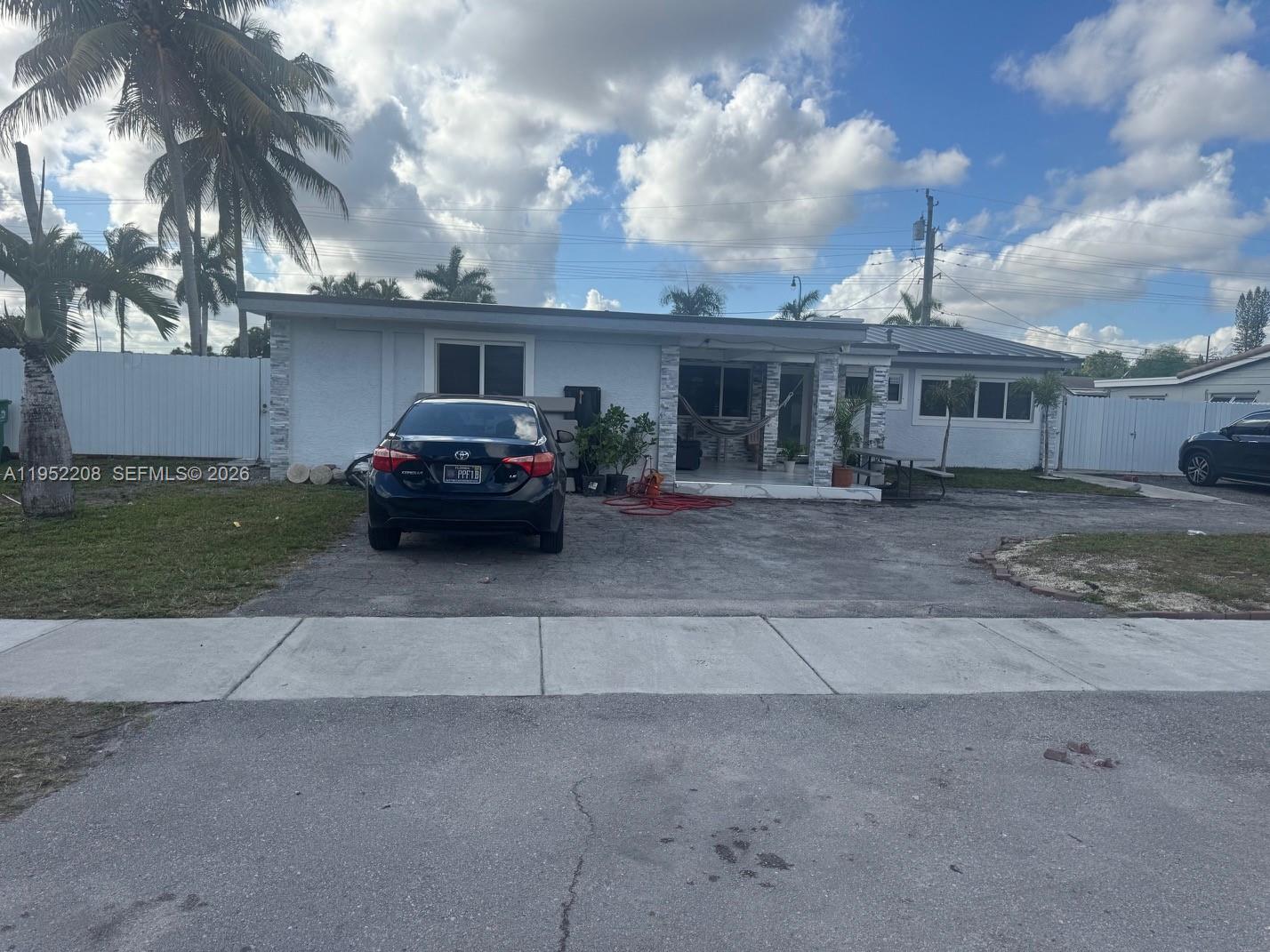 A single-story house with a paved driveway, a black sedan, and a covered front porch — 19700 NW 6th Pl, Miami Gardens FL 33169, MIAMI GARDENS, FL