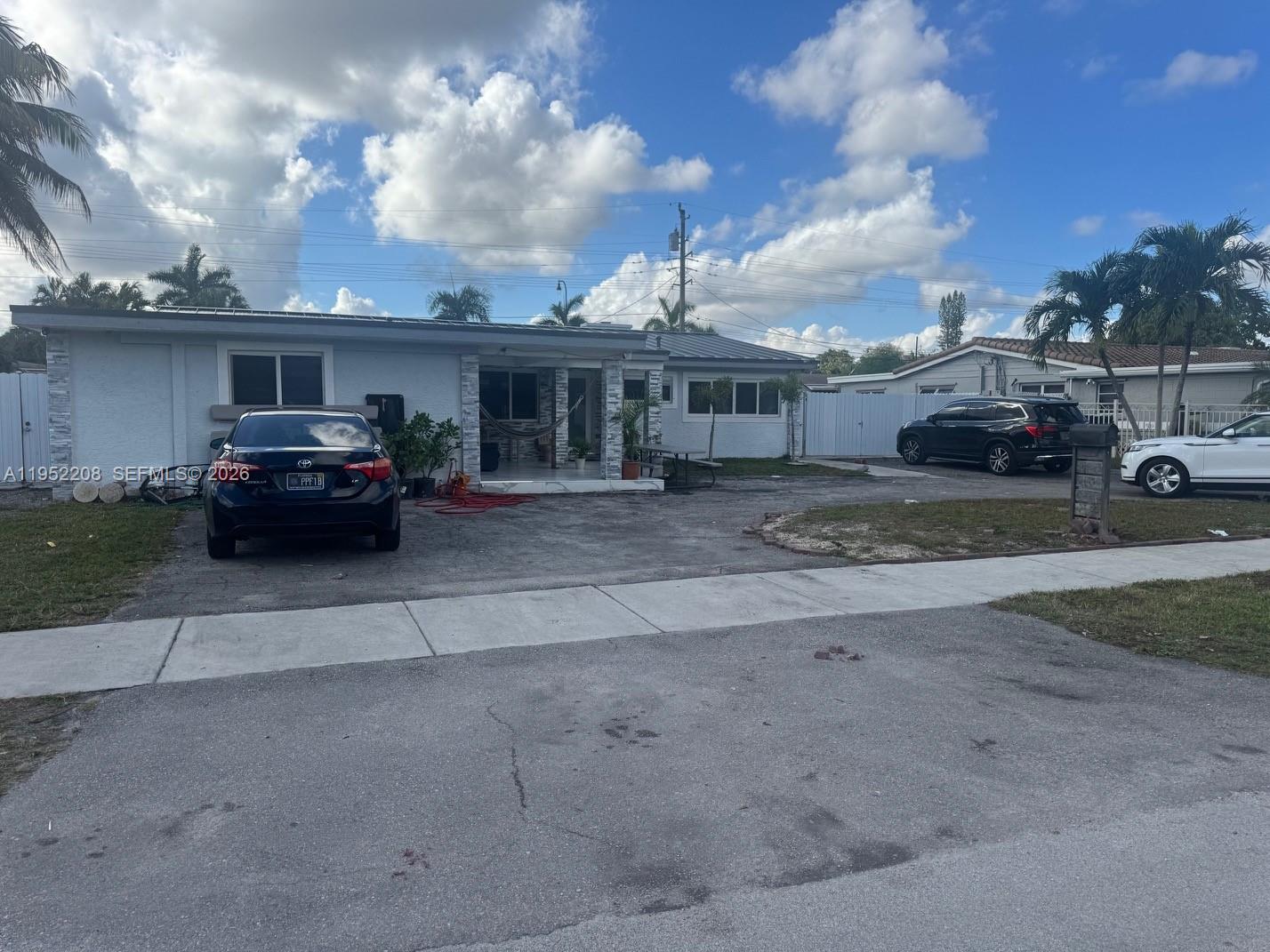 A single-story house with a gray exterior, a paved driveway, and three parked cars — 19700 NW 6th Pl, Miami Gardens FL 33169, MIAMI GARDENS, FL