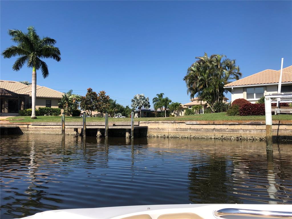 A view from a boat looking toward a residential canal bulkhead and waterfront homes — 3524 TERIN COURT, PUNTA GORDA, FL
