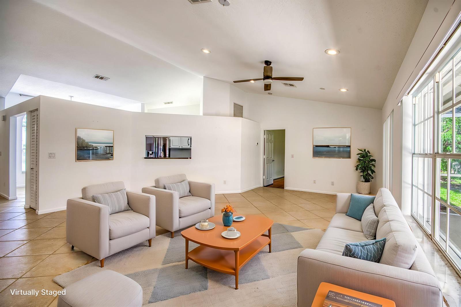 A living room with tile floors, a ceiling fan, and a sofa facing two armchairs — 252 Moccasin Trail W, Jupiter FL 33458, JUPITER, FL