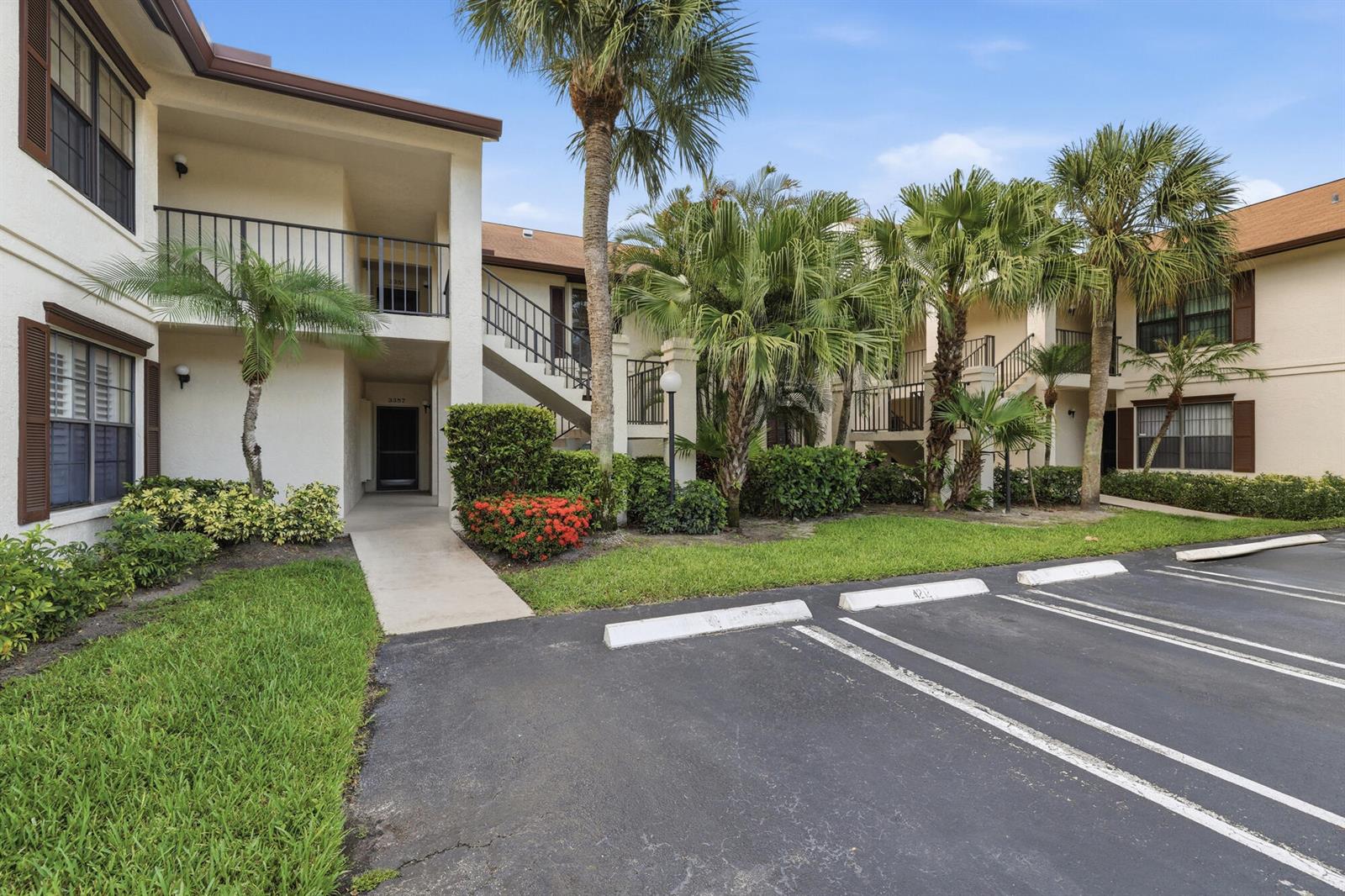 A two-story apartment building with a parking lot, palm trees, and landscaped green space — 3357 Jog Park Drive # 4212c, FL 33467, FL
