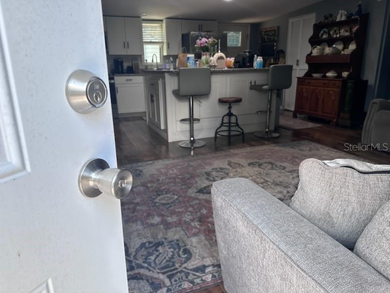 A view from a doorway into a kitchen with an island, barstools, and living area — 45506 MAGNOLIA STREET, PAISLEY, FL