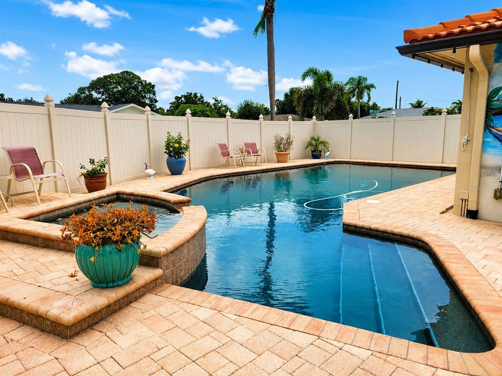 A backyard swimming pool with a spa, brick paver patio, and white vinyl privacy fence — 9391 118TH LANE, SEMINOLE, FL