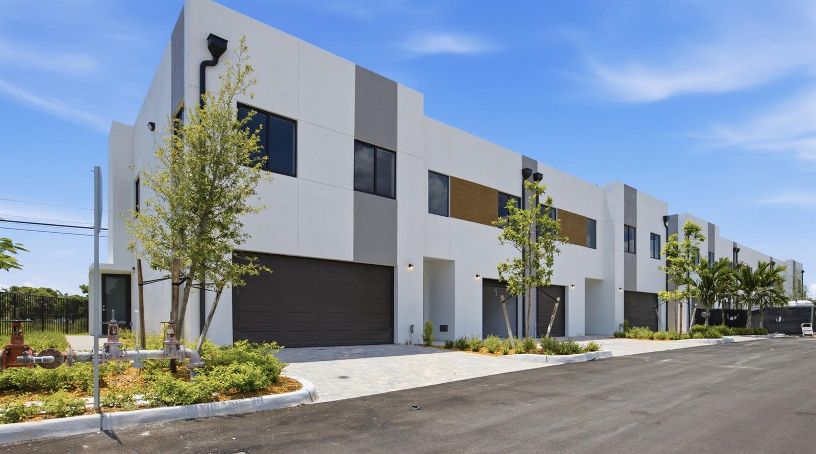 A row of modern, white two-story townhouses with dark garage doors and paved driveways — 1548 NW 1st Avenue, Pompano Beach FL 33060, POMPANO BEACH, FL