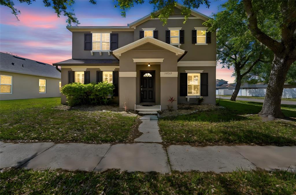 A two-story suburban house with a gray exterior, dark shutters, and a front walkway — 14759 ROYAL POINCIANA DRIVE, ORLANDO, FL