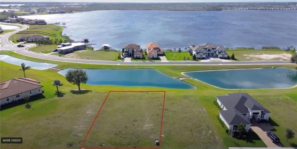 An aerial view shows a vacant rectangular lot outlined in red near a lake — 808 WATERFERN TRAIL DRIVE, AUBURNDALE, FL