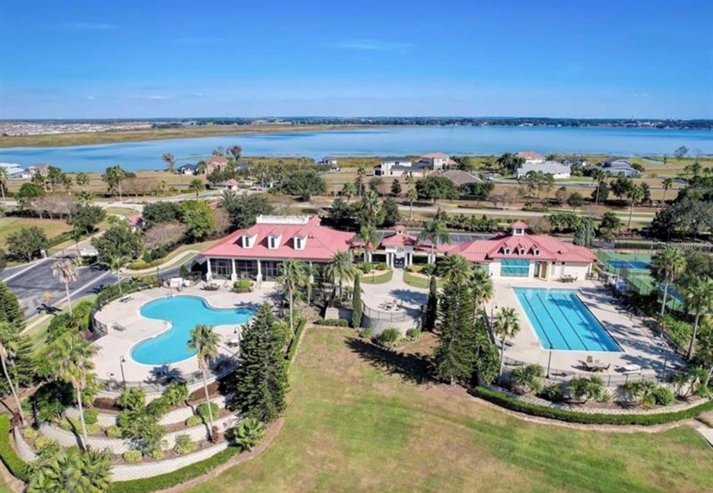 An aerial view shows a community clubhouse with two swimming pools and a large lawn — 808 WATERFERN TRAIL DRIVE, AUBURNDALE, FL