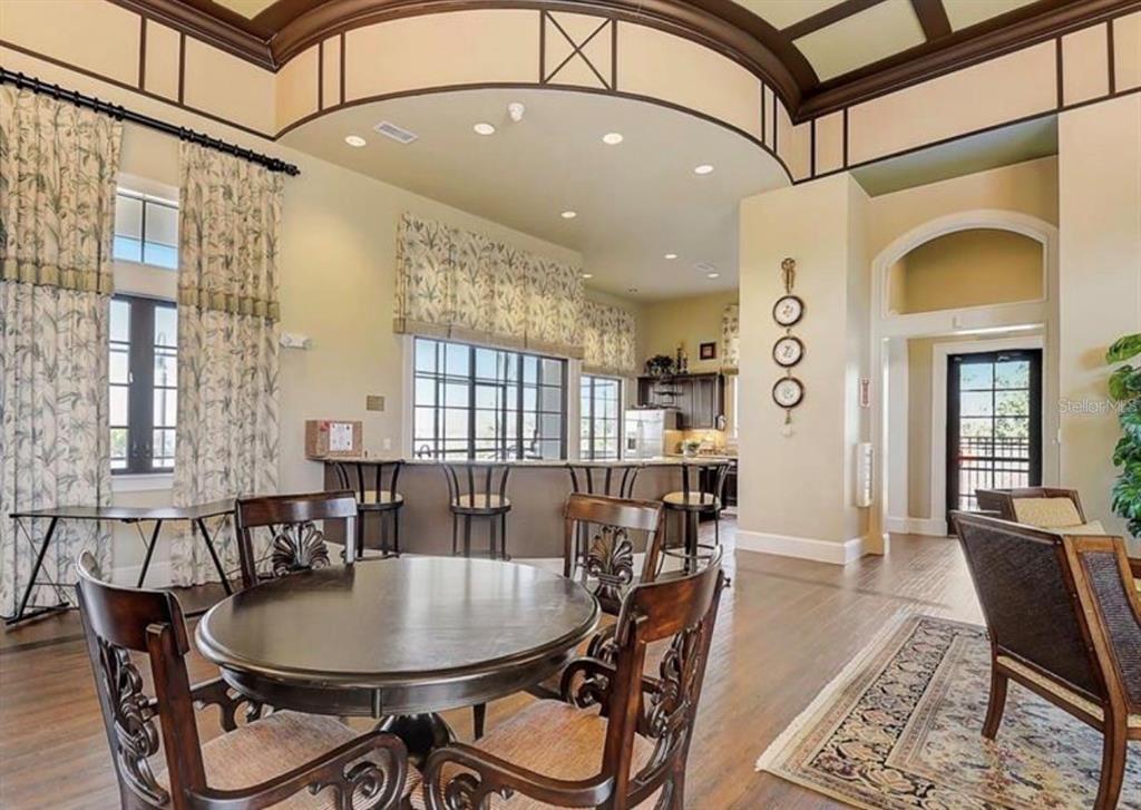 A dining area with a round table and chairs opens to a kitchen with bar seating — 808 WATERFERN TRAIL DRIVE, AUBURNDALE, FL