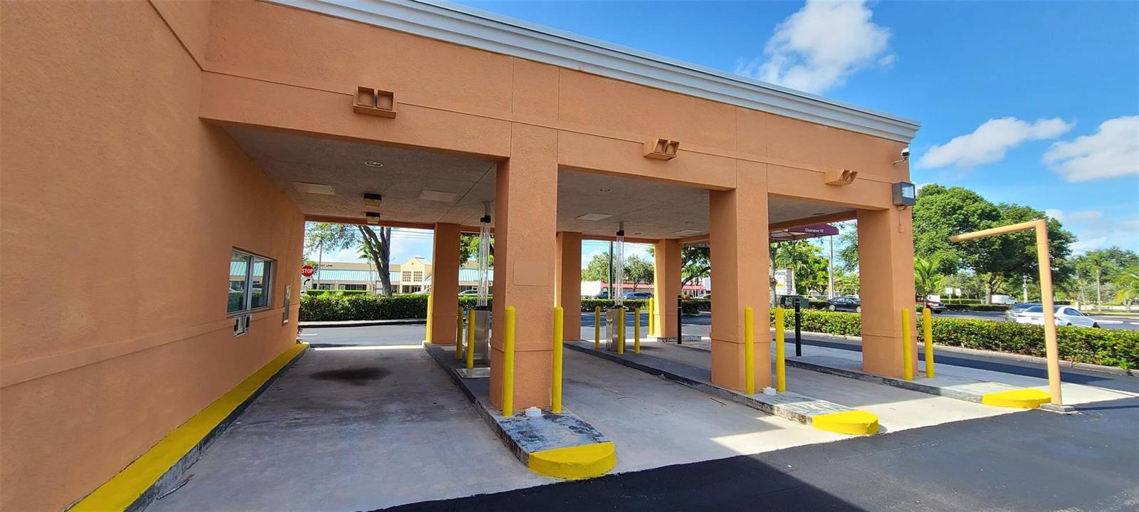 A drive-thru lane with yellow bollards and a covered concrete area outside a commercial building — 5300 Coconut Creek Parkway, Margate FL 33063, MARGATE, FL