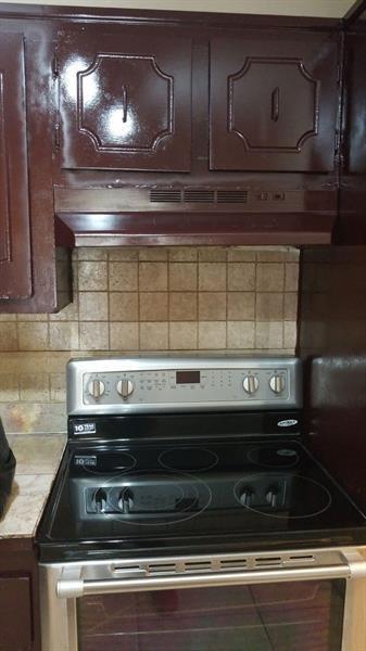 A kitchen features a stainless steel electric range beneath a dark brown cabinet and hood — 4324 NW 9th Avenue # 3c, Pompano Beach FL 33064, POMPANO BEACH, FL