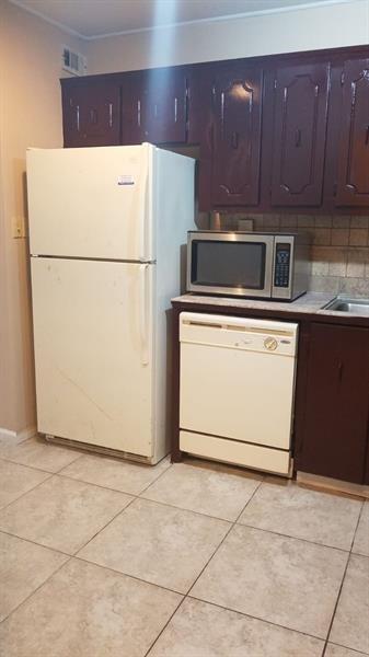 A kitchen features a white refrigerator, a dishwasher, a microwave, and dark brown cabinets — 4324 NW 9th Avenue # 3c, Pompano Beach FL 33064, POMPANO BEACH, FL