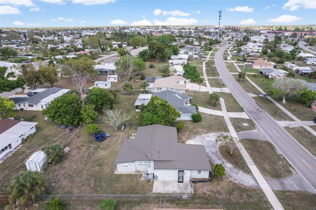 An aerial view shows a single-story house with a brown roof and a large yard — 3425 HARBOR BOULEVARD, PORT CHARLOTTE, FL