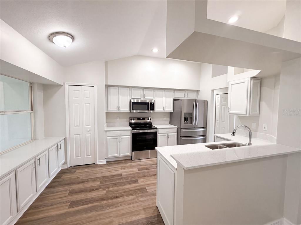 A kitchen with white cabinets, stainless steel appliances, and a breakfast bar — 5217 PONCE DE LEON BOULEVARD, SEBRING, FL