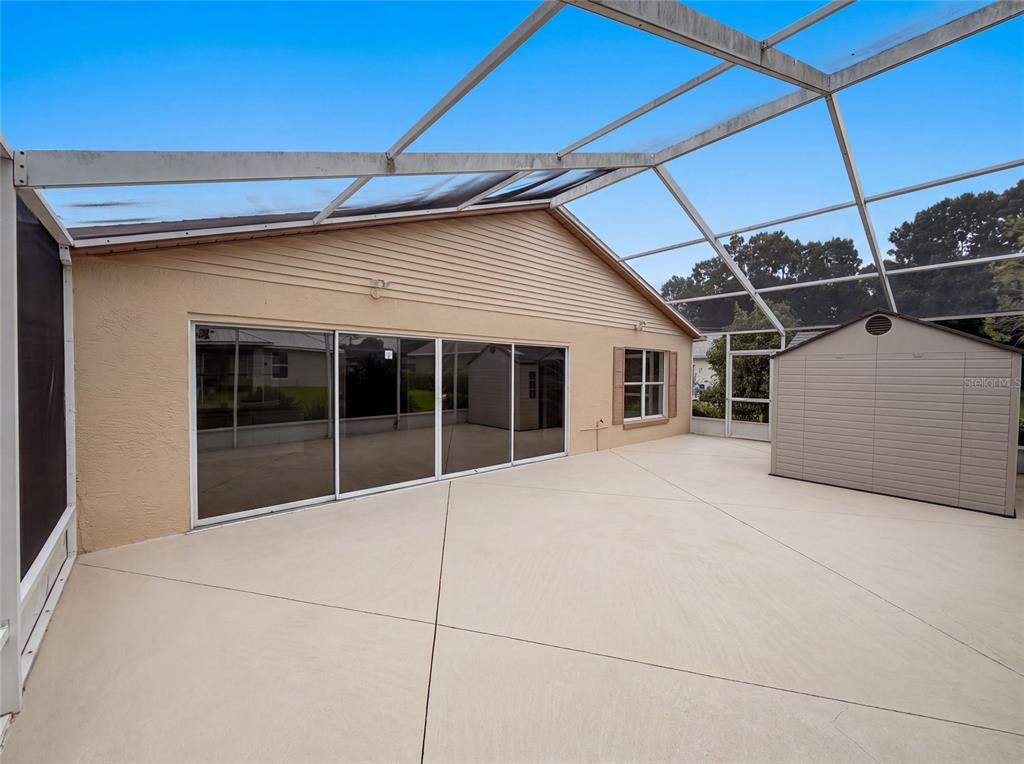 A covered patio features a concrete floor, sliding glass doors, and a detached storage shed — 5217 PONCE DE LEON BOULEVARD, SEBRING, FL
