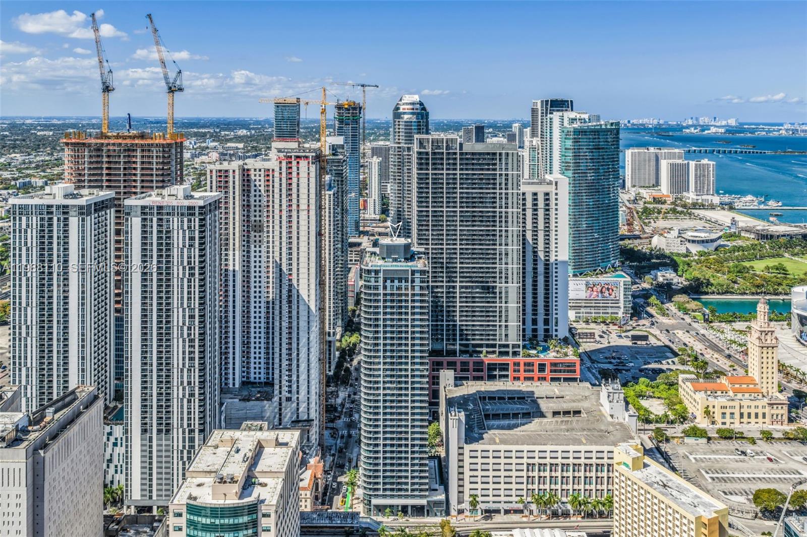 An aerial view of a dense urban skyline featuring numerous high-rise buildings and construction cranes — 121 NE 5th St # 902, Miami FL 33132, MIAMI, FL