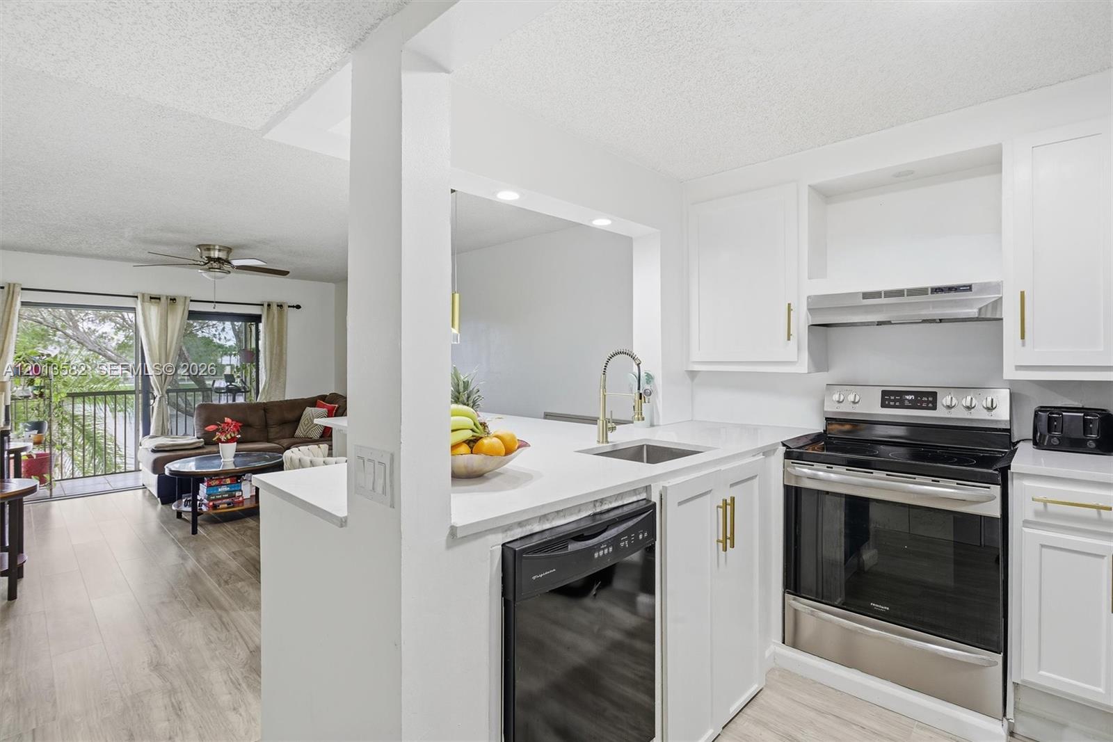 A kitchen features white cabinets, stainless steel appliances, and a white countertop with a sink — 5501 Lakeside Dr # 204, Margate FL 33063, MARGATE, FL