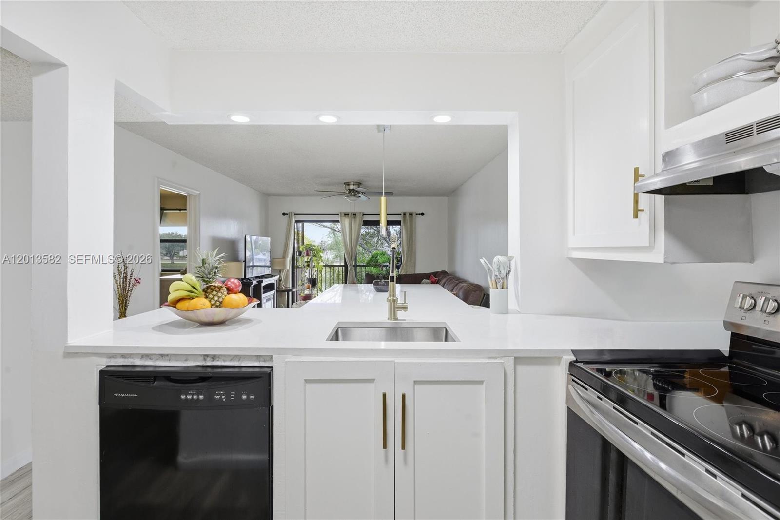 A living room features a brown sectional sofa, a glass coffee table, and a balcony view — 5501 Lakeside Dr # 204, Margate FL 33063, MARGATE, FL